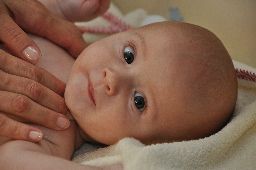 Baby Cranio-Sacral Behandlung/Therapie, Baby-Kopf blickt in die Kamera